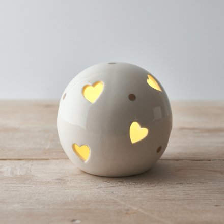 A small and simple rounded ceramic ball set with heart cut details and added gold dots 