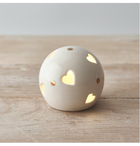 A ceramic ball with heart cut decals, gold dots features and a warm glowing LED centre 