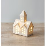 A small ceramic church inspired decoration, set with a high pointed steeple, white tone and warm led light from inside