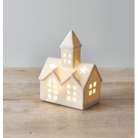 A small ceramic church inspired decoration, set with a high pointed steeple, white tone and warm led light from inside