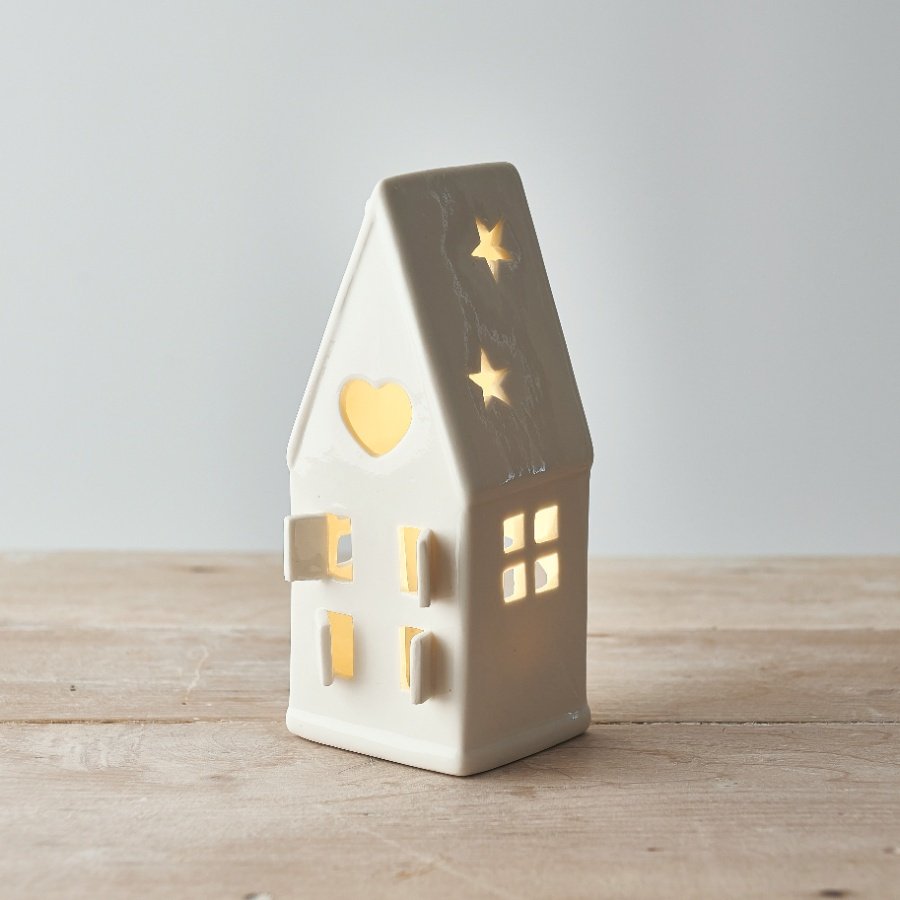  A small ceramic tlight holder with a cut star decal to the roof and open windows to complete its look 