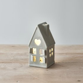 A dainty little ceramic house featuring open windows and a star cut decal to the roof 