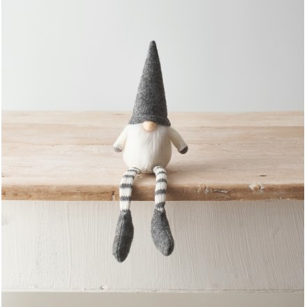 A Nordic inspired grey and cream toned fabric shelf sitting gonk with a traditional white beard and high pointed hat 