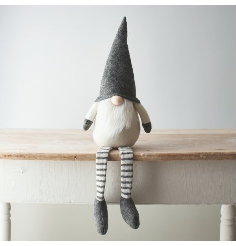 A Nordic inspired grey and cream toned fabric shelf sitting gonk with a traditional white beard and high pointed hat 