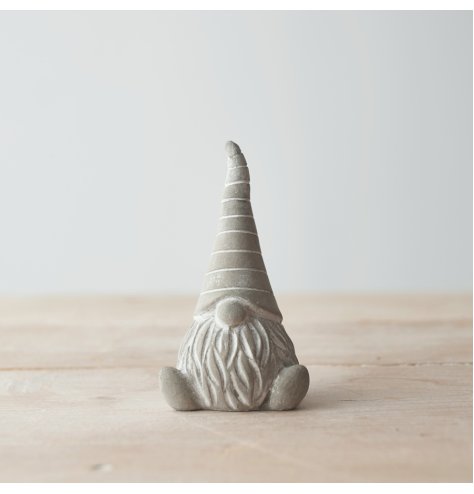 A charming little cement based sitting gonk, decorated with a striped pointy hat 