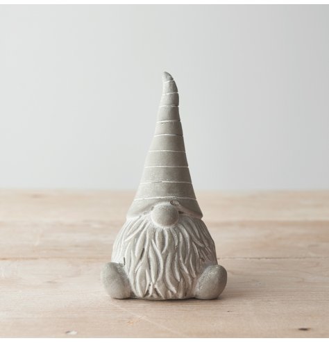 A charming little cement based sitting gonk, decorated with a striped pointy hat 