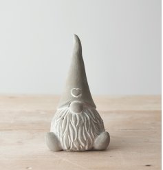 A distressed themed sitting cement gonk with a high pointed hat and bulbous nose 