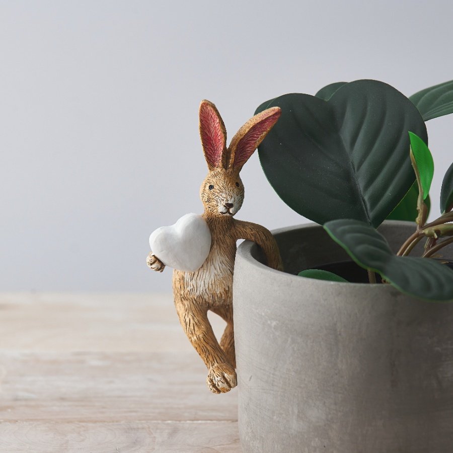 A sweet little pot hanging rabbit with a large white heart decal 