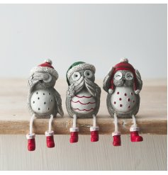 A fun and festive mix of shelf sitting Owl figures with pops of traditional colours on a grey base tone 