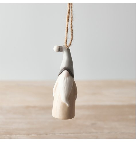 A small hanging ceramic gonk decoration set with a traditional neutral tone and smooth glaze 