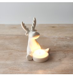 A charming and simple sitting ceramic reindeer complete with a T-light holding space 