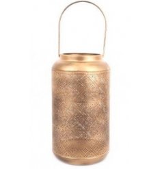 Sure to bring a Golden Luxe accent to any home space, a tall metal lantern with a cut out decal