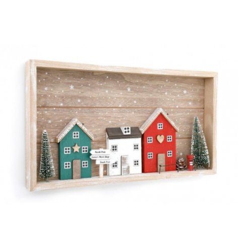 A wooden based village scene plaque set with nordic tones and festive decals around it 
