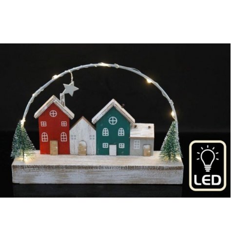 A wooden based village scene set with nordic tones and festive decals around it , finished with a warm glowing LED arch 