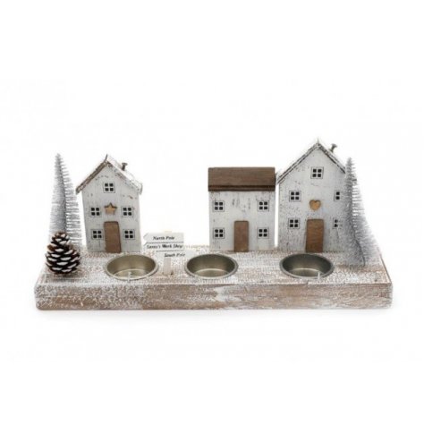 A wooden based Winter village scene complete with added snowy touches, bristle trees and a tlight holder space 