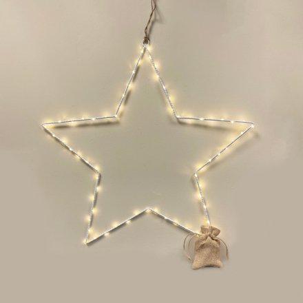 An extra large white metal wire star decoration with warm glowing LED lights and a hessian battery bag 