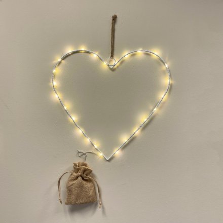 A white metal wire heart shape with fine LED lights woven around. 