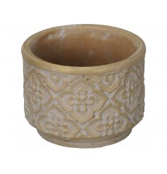  An overly distressed inspired concrete pot with a terracotta colouring and floral embossed patterning 