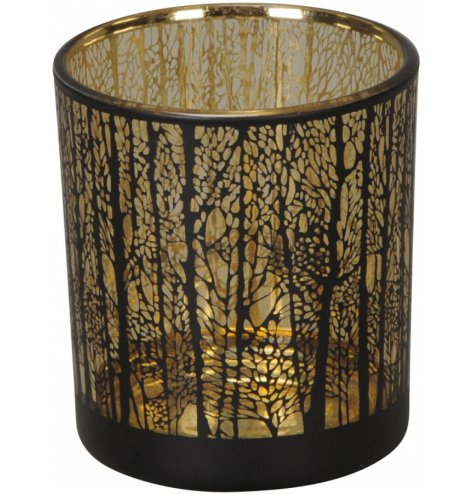 A gold lined glass t-light holder with an etched woodland tree decal across the front 