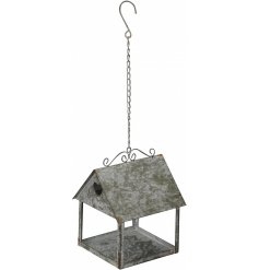 A charmingly rustic inspired metal hanging bird house with a simple heart window 