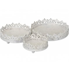 A stylishly simple set of round metal trays, complete with a patterned edge and shabby chic white wash finish 