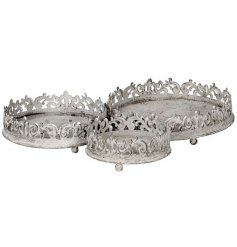 An assorted sized set of overly distressed round trays, complete with scalloped edges and a tarnished grey tone