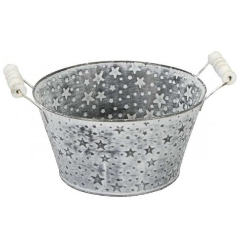 A zinc bucket covered with embossed star decals and a white washed finish 