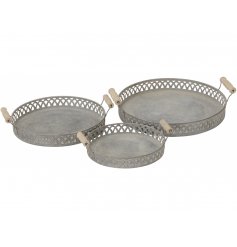 A set of assorted sized metal trays, each decorated with a rustic washed finish, wooden handles and patterned edging 