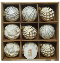 A box of mixed baubles with traditional gold and white tones, each set with stunning patterns and decals 