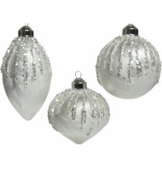 A stunning mix of winter white toned glass bauble, each set with a glittery trim surrounding it 