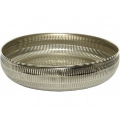   A large metal bowl with a tarnished silver tone and hammered edging 