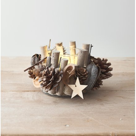 A glass candle pot surrounded with assorted sized and shaped twigs and pinecones 