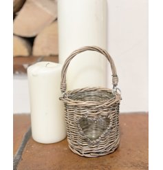  A woven wicker candle lantern set with a shaped heart central window and added handle to feature