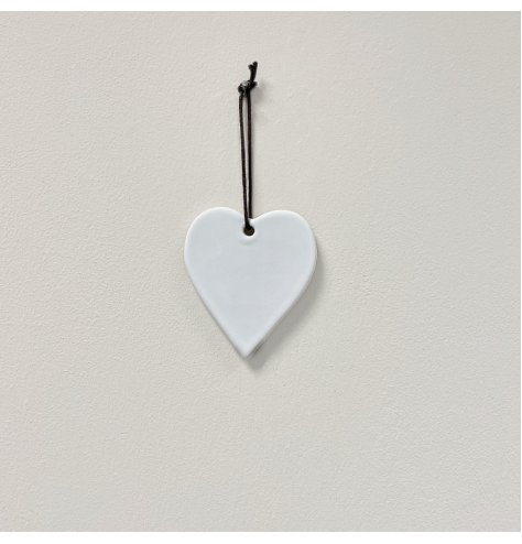 A simple ceramic heart hanging decoration in a white tone, set with a black string hanger 