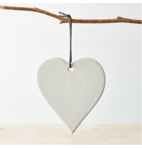 A simple ceramic heart hanging decoration in a white tone, set with a black string hanger 