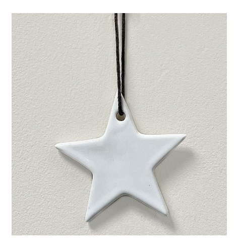 A simple ceramic star hanging decoration in a white tone, set with a black string hanger 