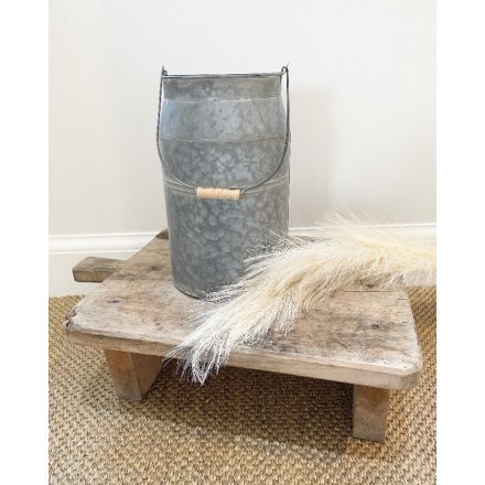 A simplistically decorated metal churn inspired planter with a zinc look and washed effect 