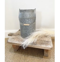 A simplistically decorated metal churn inspired planter with a zinc look and washed effect 