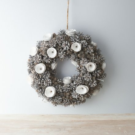 A beautifully rustic wreath with wooden flowers, pinecones and a silvery tone to set the look 