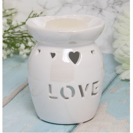 A charmingly simple white toned ceramic oil burner featuring a heart cut decal and bold LOVE finish 