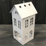 A rustic inspired t-light holder shaped as a house with cutout window detail.