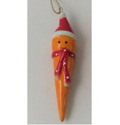 A cute and quirky ceramic carrot hanging decoration with a smiley face and festive decor 