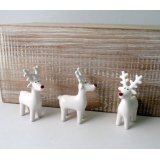 A cute little white ceramic reindeer with a festive red nose 
