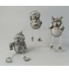 An assortment of posed woodland owl figures, with soft grey hues and a subtle glittery finish to each 