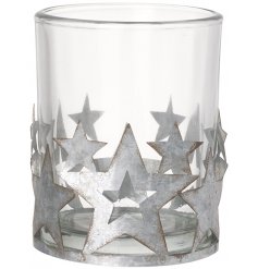A chic glass candle holder with a mix of silver star decorations. Each has a distressed finish. 