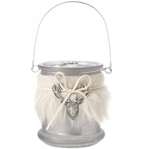 A glass candle jar set with a faux fur sleeve and detailed stag charm on the front centre 