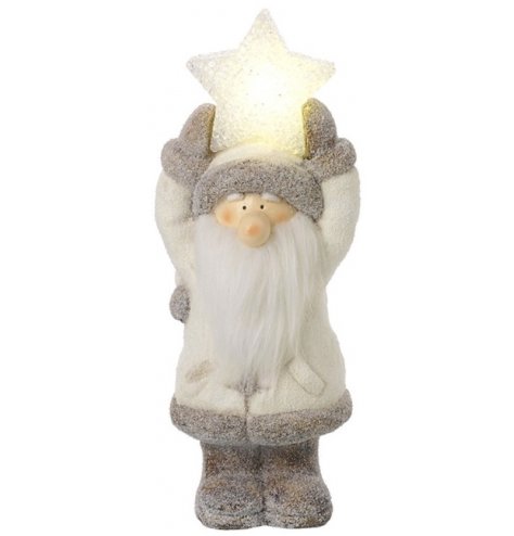 A sweet sitting Santa figure set with a snowy touch and warm glowing LED feature 