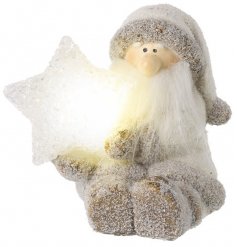 A sweet little sitting Santa Figure covered with a flurry of glittery snow and set with a warm glowing LED Star 
