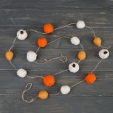 Sure to bring an autumnal flare to any home space, a string garland made up of woollen pumpkins 