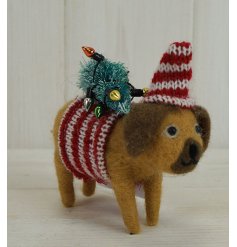 A fuzzy woollen dog decoration with festive accents and knitted clothes  